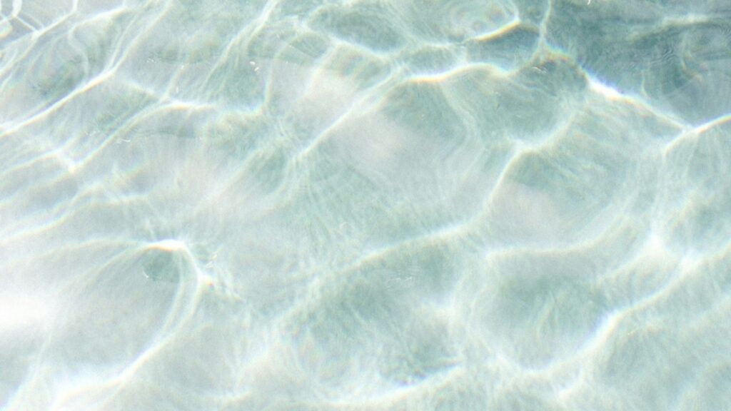 海の浅瀬の水面の様子を写した写真。透明度の高い海水で、波紋が揺れて光っている。