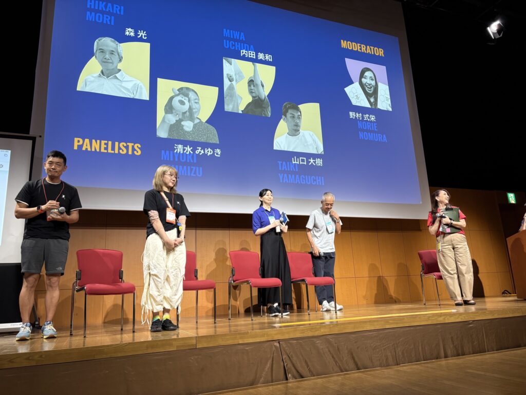 檀上に立つ4人のスピーカー。向かって右には、モデレーターの女性が立っている。