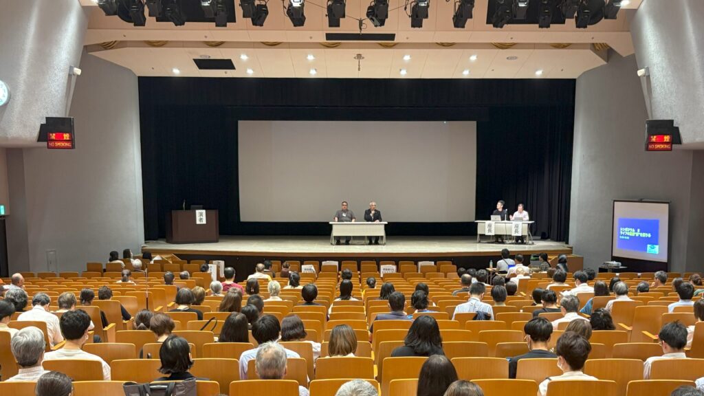 第33回視覚障害リハビリテーション研究発表大会の様子。ステージ上に4人の登壇者がいる。
