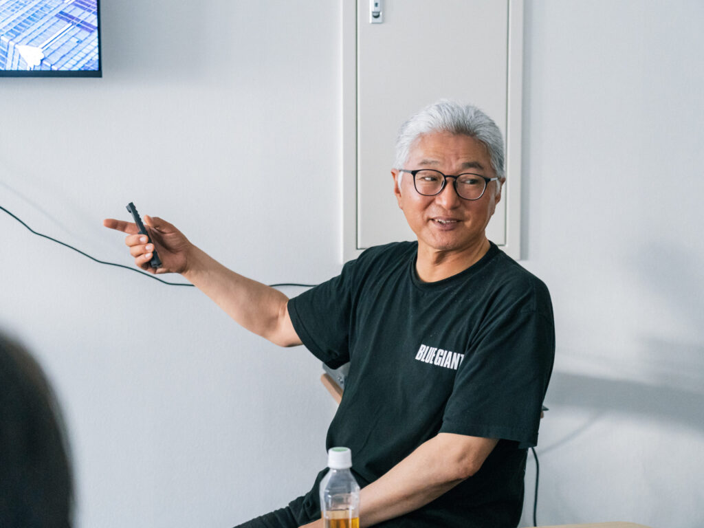 ペンを手に持ちながら、スクリーンを指さして解説している檀さん。