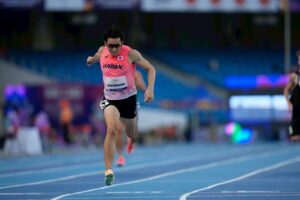 競技中の福永凌太選手。サングラスに日本代表ユニフォーム姿で両腕を大きく振って走っている。