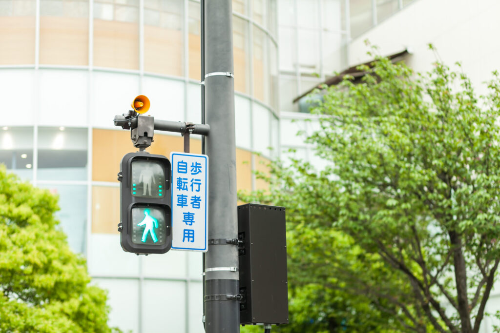 横断歩道の歩行者自転車用の音響信号機。青になっている。