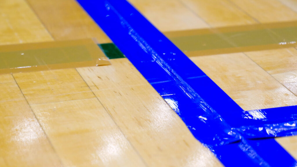 コートのラインをクローズアップした写真。テープの下に突起が仕込まれている。