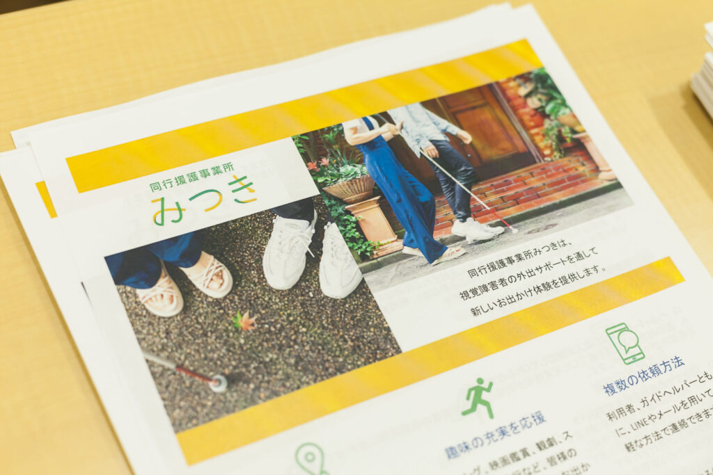 2024年のイベントで配布した「同行援護事業所みつき」のチラシ。黄色と緑がメインのデザイン。