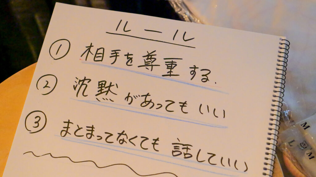 ルールの書かれたスケッチブック。内容を以下に記載「ルール、1.相手を尊重する。2.沈黙があってもいい。3.まとまってなくても話していい。」文字は手書きで温かみを感じる。