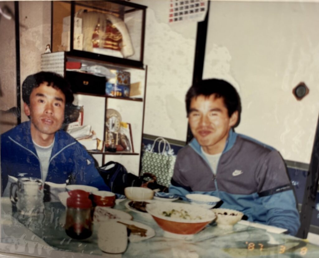 学生時代の上田先生と岡先生の写真。ジャージを着た2人が写っている。