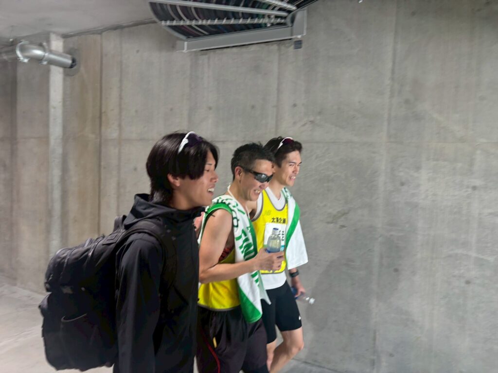 レース直後、肩を組みながら笑顔で歩く三國さんと伴走者の2人。