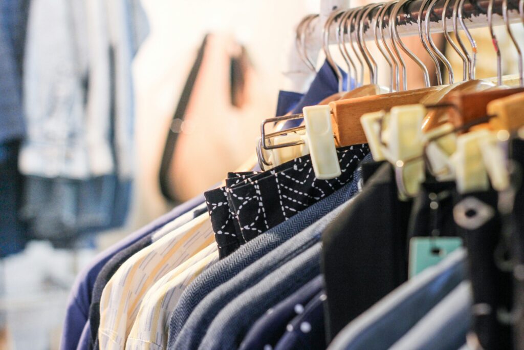 洋服店のハンガーにたくさんの服がかかっている様子。
