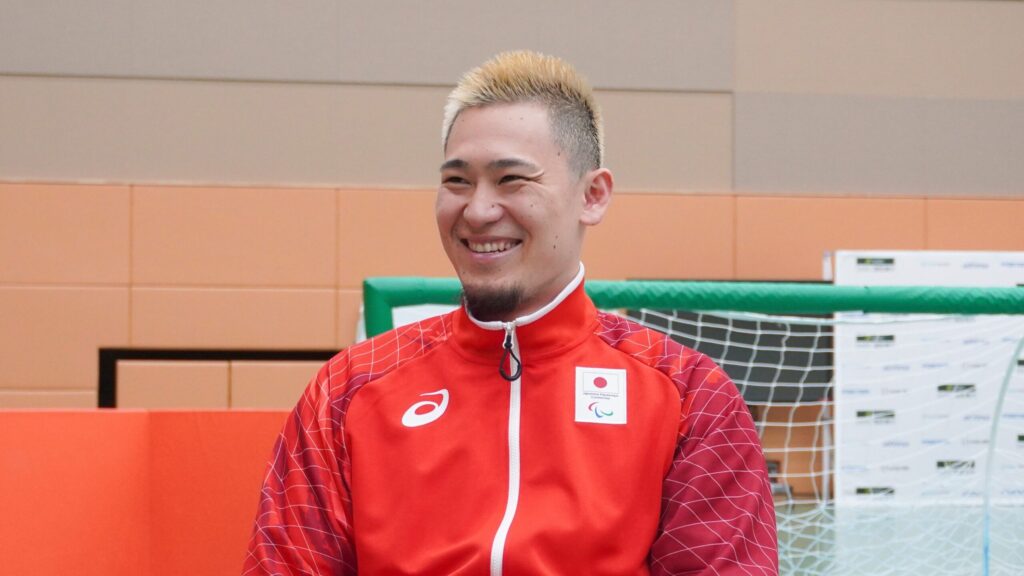 アジアパラ日本代表の赤いジャージを着た笑顔の宮食選手。