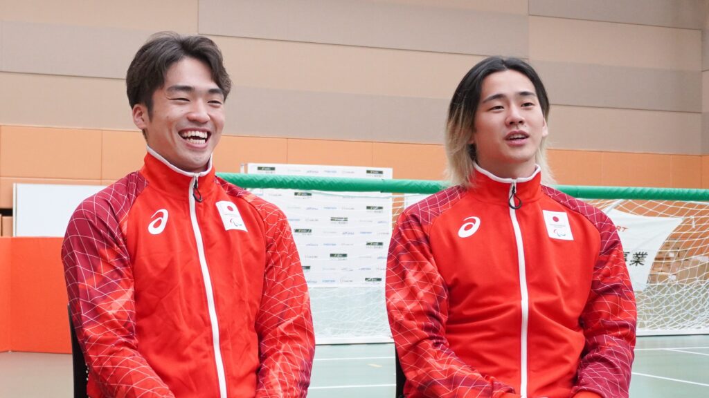 アジアパラ日本代表の赤いジャージを着た笑顔の鳥居選手と行弘選手。